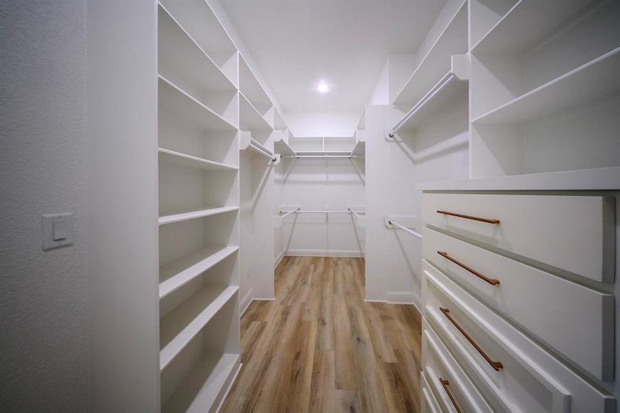 Spacious closet featuring light wood-style flooring Spacious closet featuring light wood-style flooring