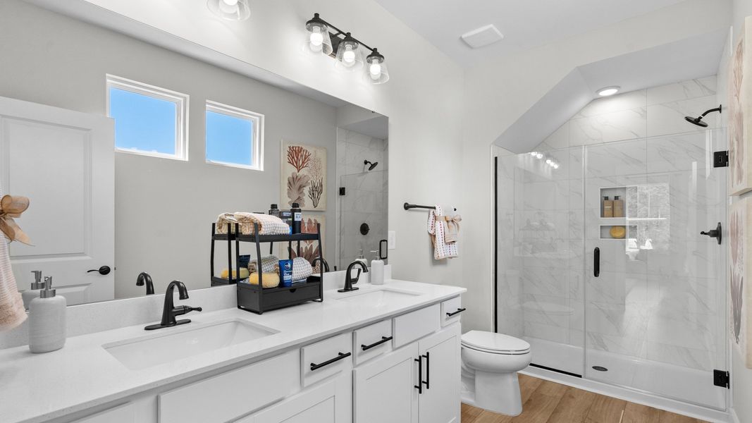 Primary bathroom in the Summit home plan with modern finishes and dual vanities.