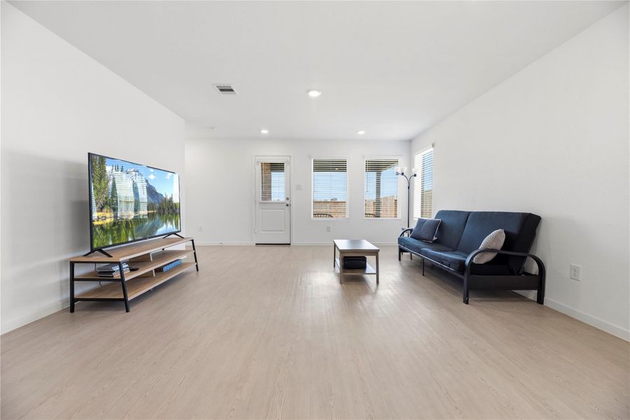Family room with beautiful laminate flooring and backyard views.
