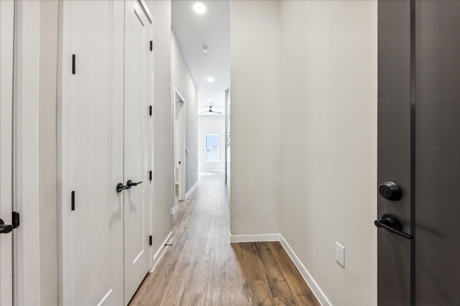 A well-lit corridor welcomes you home with durable wood-look flooring and clean lines. A well-lit corridor welcomes you home with durable wood-look flooring and clean lines.