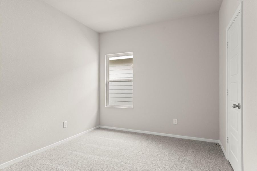 Unfurnished bedroom with light colored carpet and baseboards