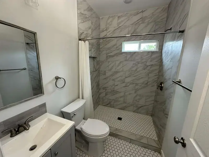 Full bathroom with vanity and a shower stall