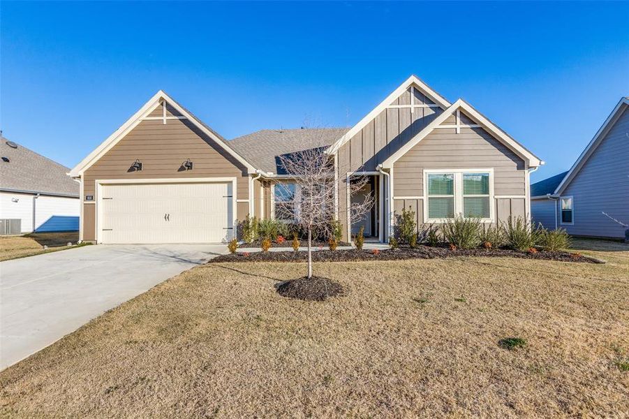 View of front of home with a garage and a front yard