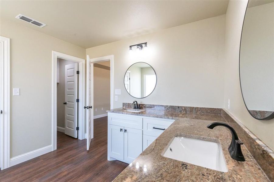 Double vanity with granite-style countertop, undermount sinks, and matte black fixtures