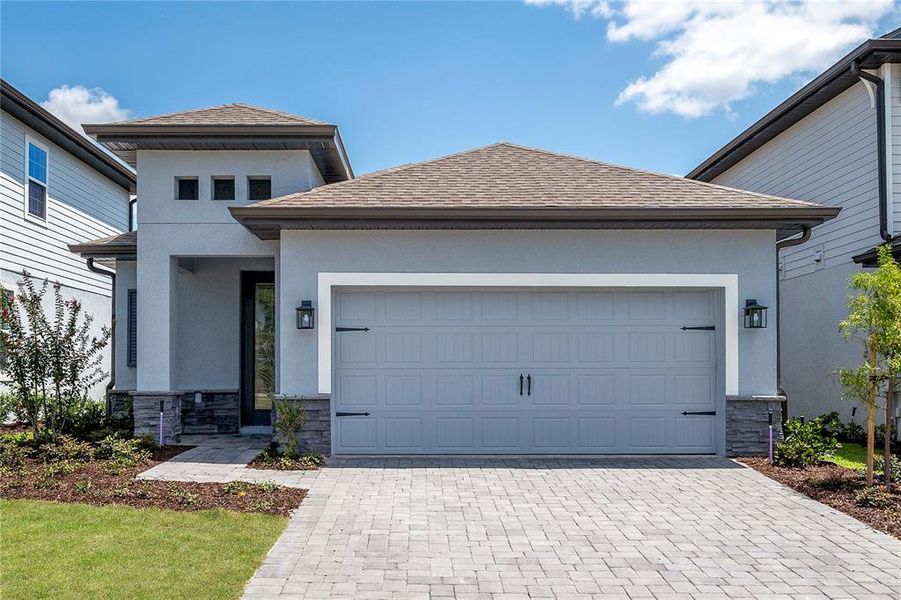 Front exterior of a new home in Reunion Village, Kissimmee, FL, highlighting curb appeal (Image 1).