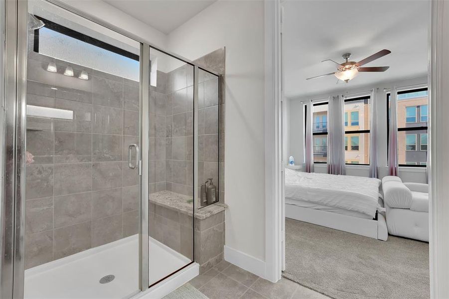 Bathroom featuring ceiling fan, tile patterned flooring, and an enclosed shower