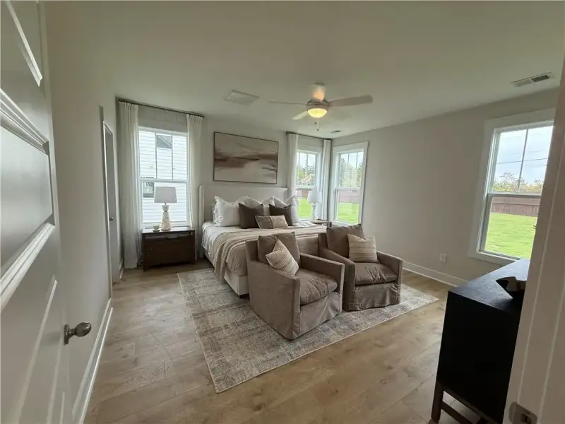 Warm wood flooring and multiple windows enhance th