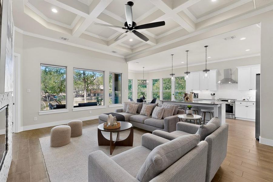 Open-concept living space with coffered ceilings, recessed lighting, and wood-finish flooring