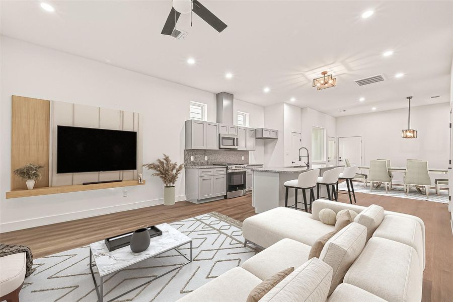 This is a modern, open-concept living space featuring a cozy seating area, a mounted TV, and a stylish kitchen with a central island and bar stools. The dining area is in the background, and the design is highlighted by sleek finishes, recessed lighting, and a ceiling fan.- Virtual Staging This is a modern, open-concept living space featuring a cozy seating area, a mounted TV, and a stylish kitchen with a central island and bar stools. The dining area is in the background, and the design is highlighted by sleek finishes, recessed lighting, and a ceiling fan.- Virtual Staging
