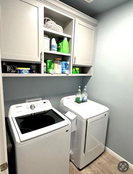 Functional laundry room offers upper cabinetry for convenient storage solutions.