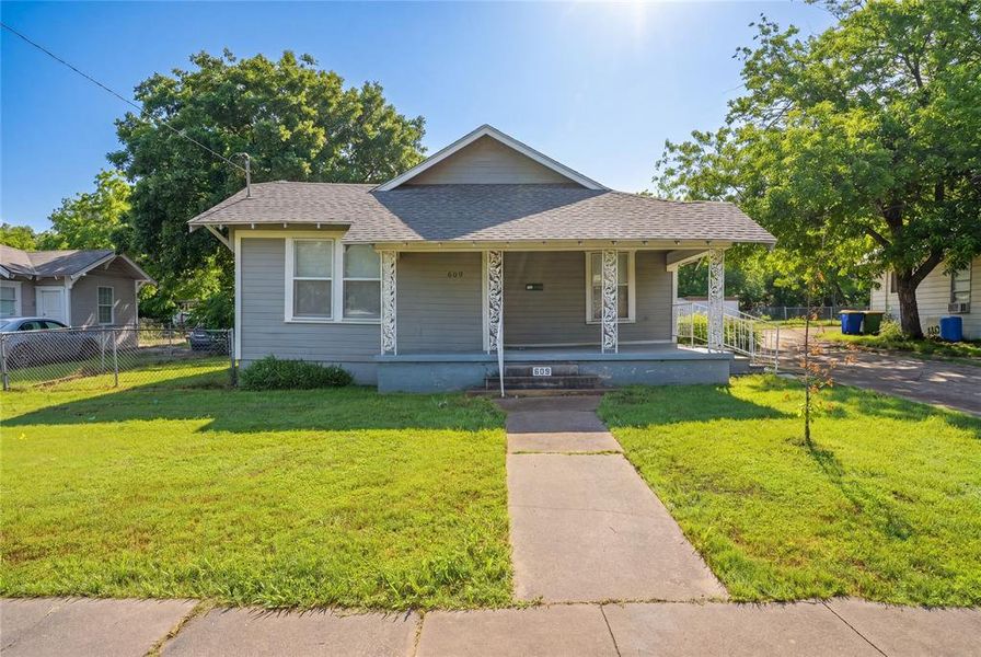 Traditional single-story home featuring a covered front porch with decorative railings