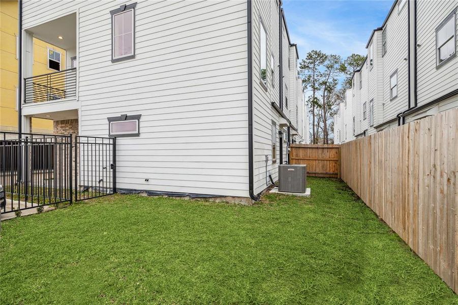 Backyard of a modern home with a well-maintained grassy area.