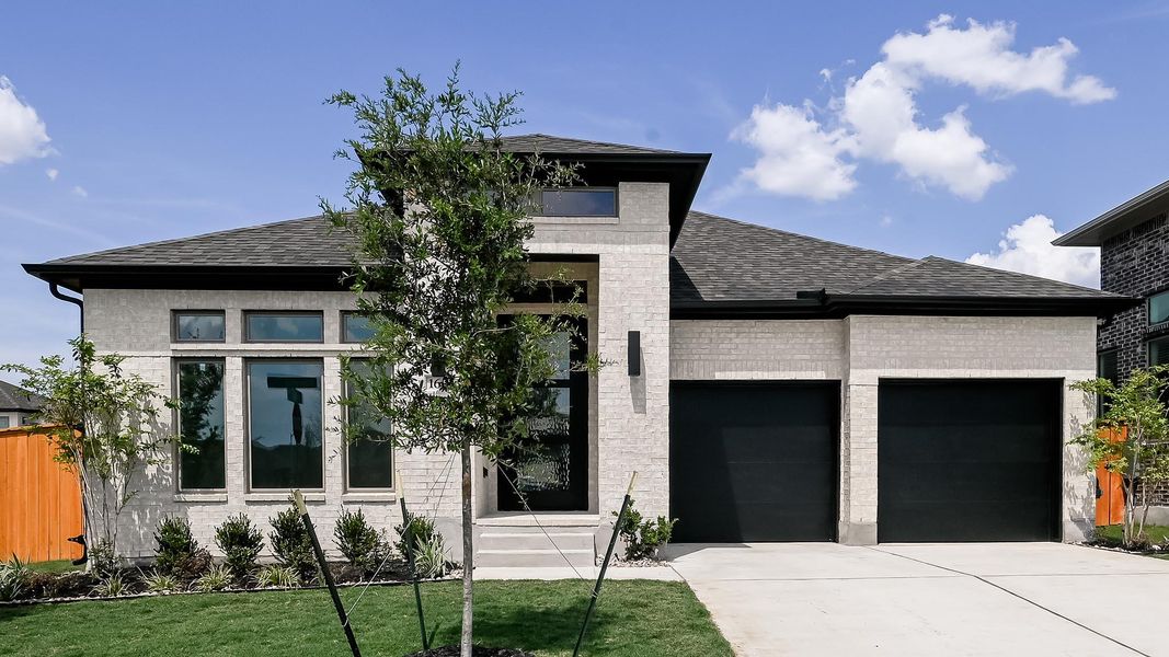 View of front facade featuring a garage, roof with shingles, concrete driveway, a front yard, and brick siding View of front facade featuring a garage, roof with shingles, concrete driveway, a front yard, and brick siding