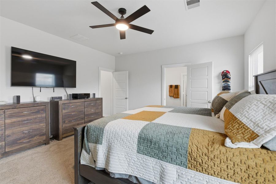 Bedroom with light colored carpet and ceiling fan