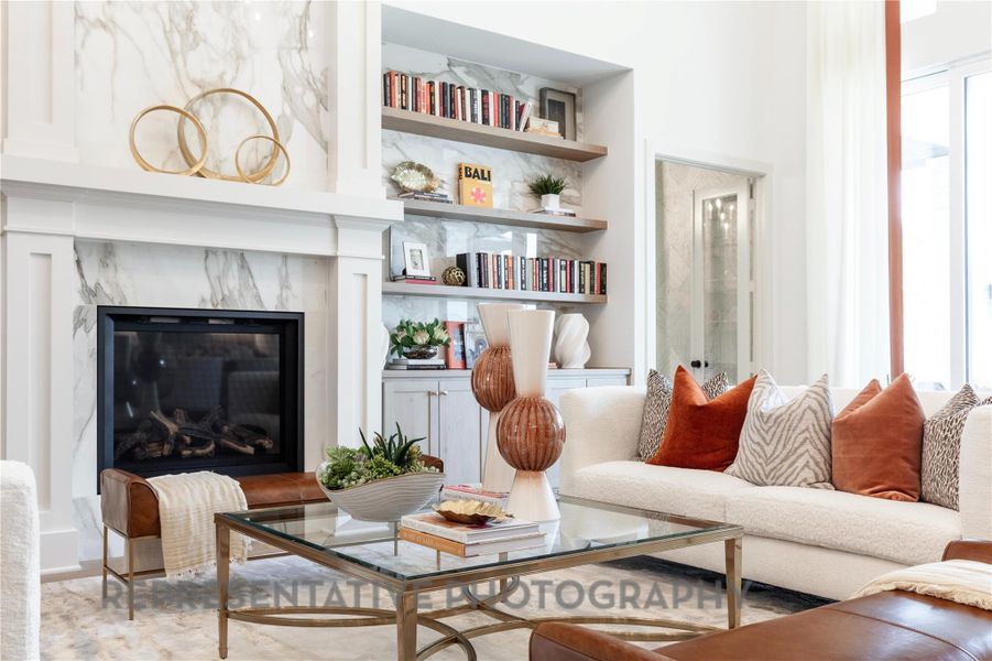 Living room featuring a healthy amount of sunlight, a fireplace, and built in shelves Living room featuring a healthy amount of sunlight, a fireplace, and built in shelves
