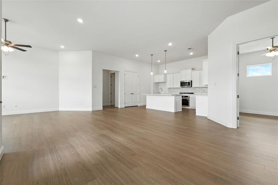 Unfurnished living room with ceiling fan, recessed lighting, and dark wood finished floors