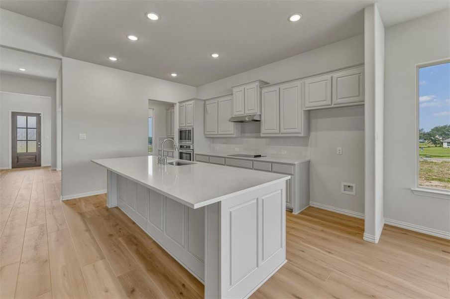 Expansive kitchen island with a light-colored countertop and integrated sink Expansive kitchen island with a light-colored countertop and integrated sink