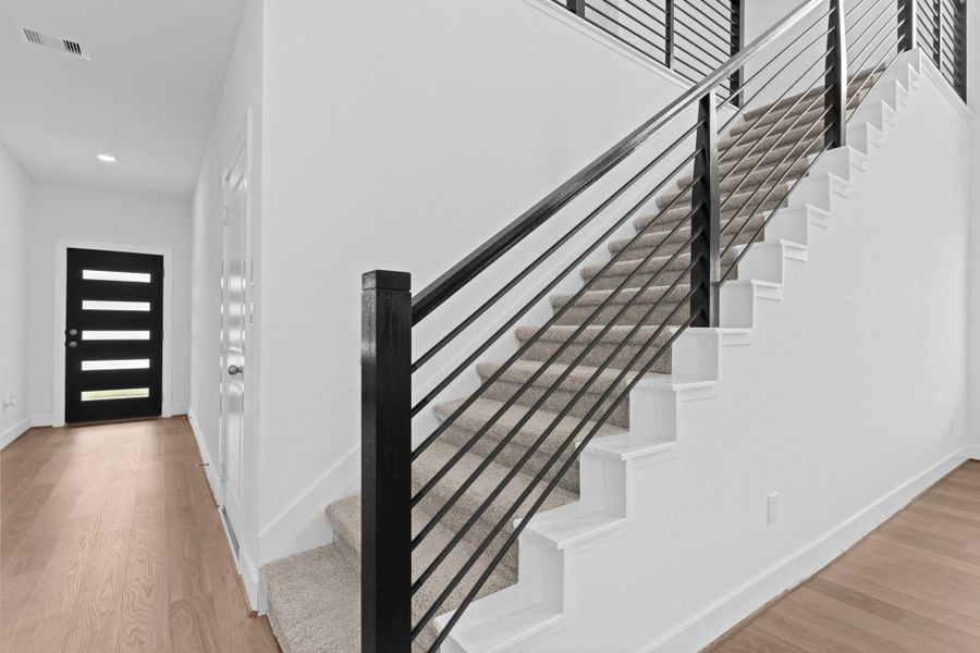 The stylish wrought iron staircase and open hallway highlight the home’s modern design and high-end finishes, tying together the entryway with elegance and flow. **Image Representative of Plan Only and May Vary as Built**. The stylish wrought iron staircase and open hallway highlight the home’s modern design and high-end finishes, tying together the entryway with elegance and flow. **Image Representative of Plan Only and May Vary as Built**.
