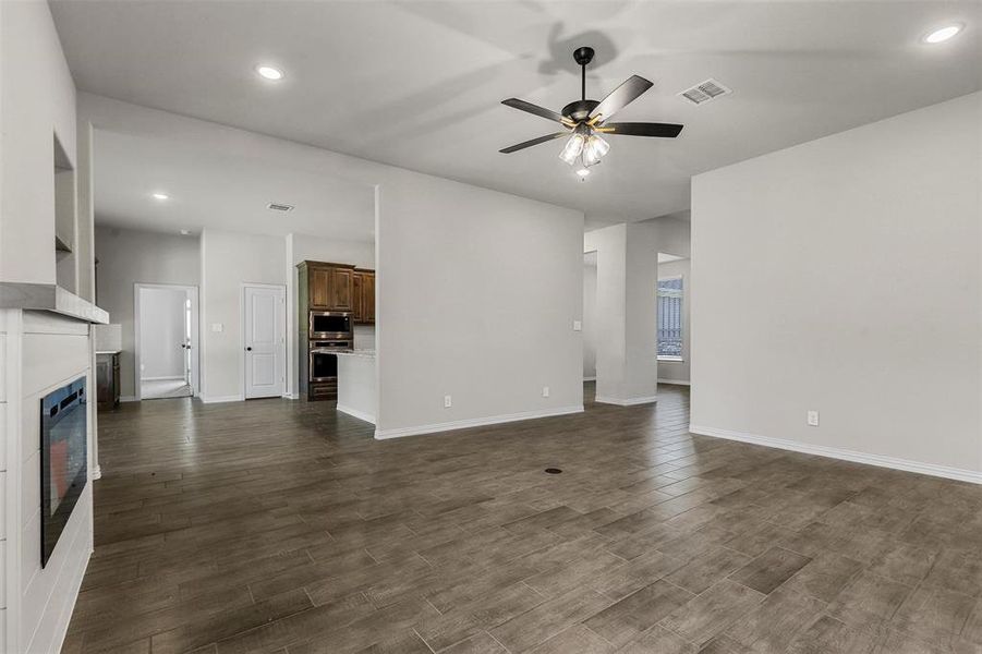 Unfurnished living room featuring dark hardwood / wood-style flooring and ceiling fan