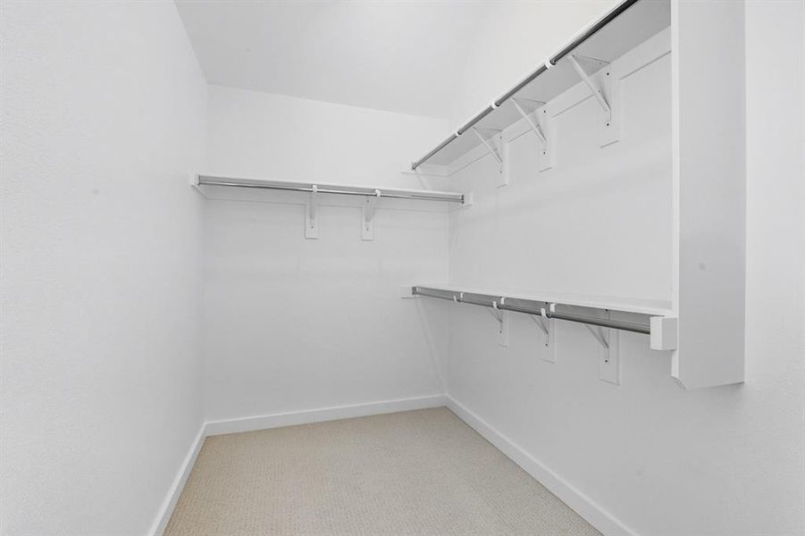 Spacious closet with light colored carpet Spacious closet with light colored carpet