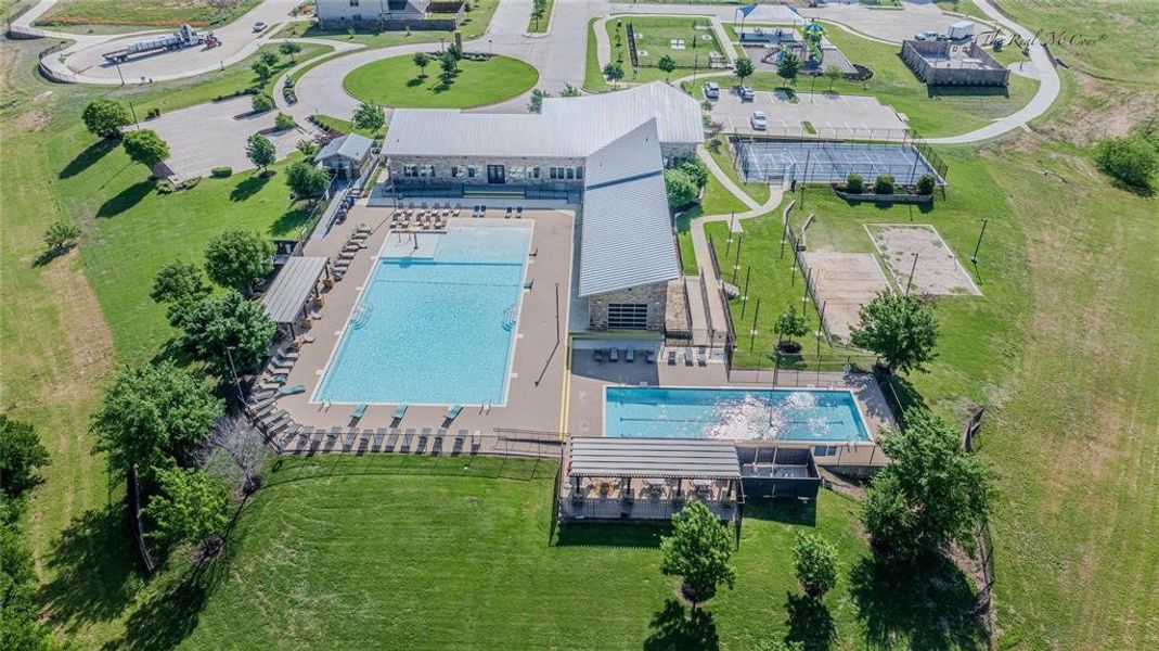 Expansive community amenity center featuring a large swimming pool, a separate lap pool, covered outdoor seating, tennis courts, and a sand volleyball court Expansive community amenity center featuring a large swimming pool, a separate lap pool, covered outdoor seating, tennis courts, and a sand volleyball court