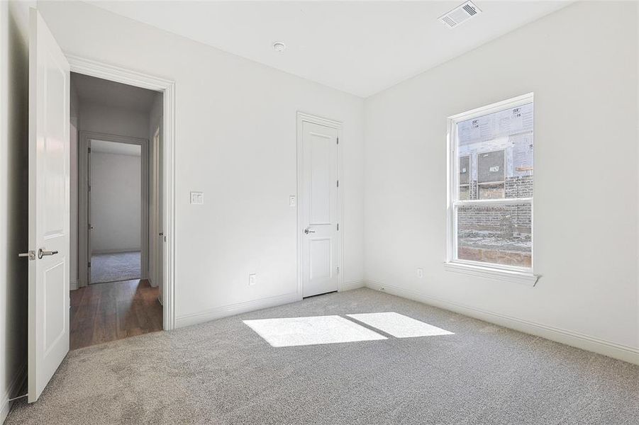 Unfurnished bedroom featuring light colored carpet and baseboards
