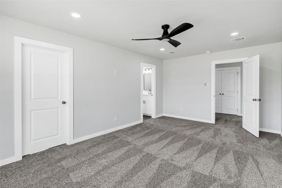 Unfurnished bedroom with carpet flooring, baseboards, recessed lighting, ensuite bathroom, and a ceiling fan