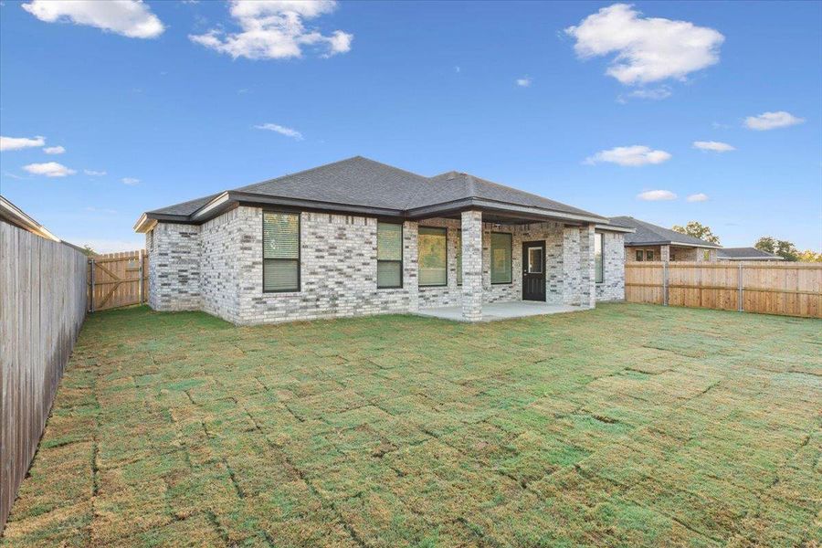 Back of house featuring a patio, a fenced backyard, and brick siding Back of house featuring a patio, a fenced backyard, and brick siding
