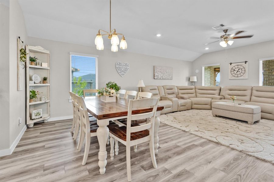 This spacious and bright open-concept living and dining area features stylish wood-look flooring, Large windows provide natural light, while elegant light fixtures add a warm touch. Perfect for entertaining and family gatherings.