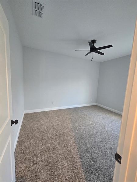 Carpeted spare room with baseboards and ceiling fan