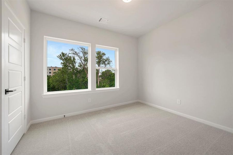 Bedroom featuring light gray carpet flooring and white painted walls Bedroom featuring light gray carpet flooring and white painted walls