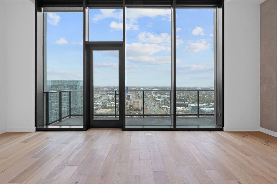 This spacious living area boasts floor-to-ceiling windows, bathing the room in natural light and offering panoramic views of Downtown Austin.