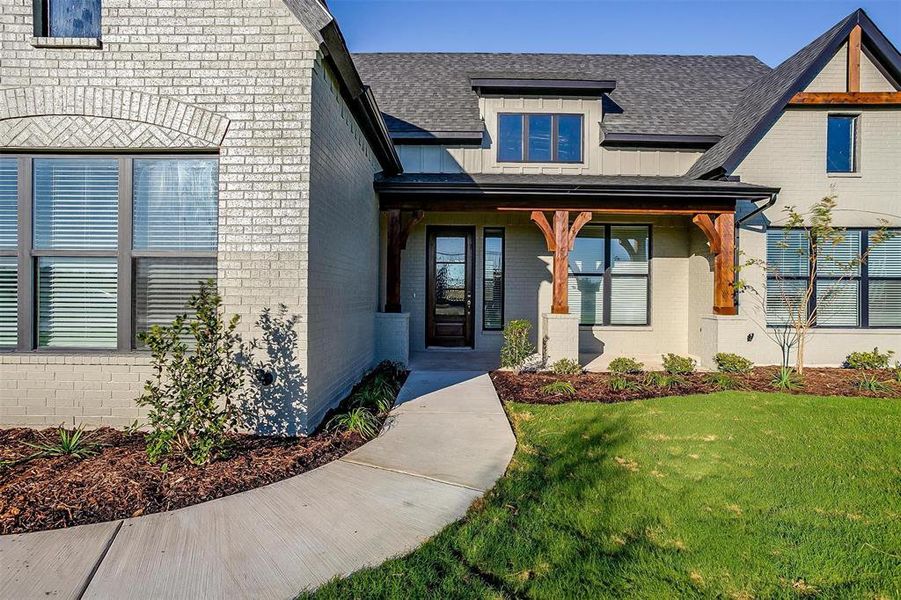 View of exterior entry featuring a lawn