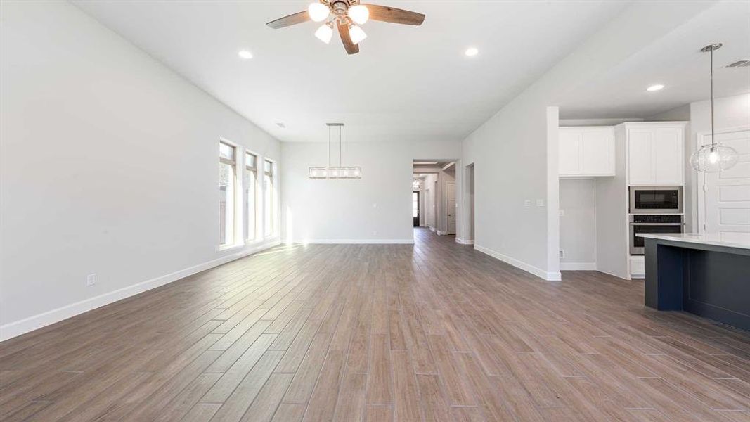 Unfurnished living room with light hardwood / wood-style floors and ceiling fan