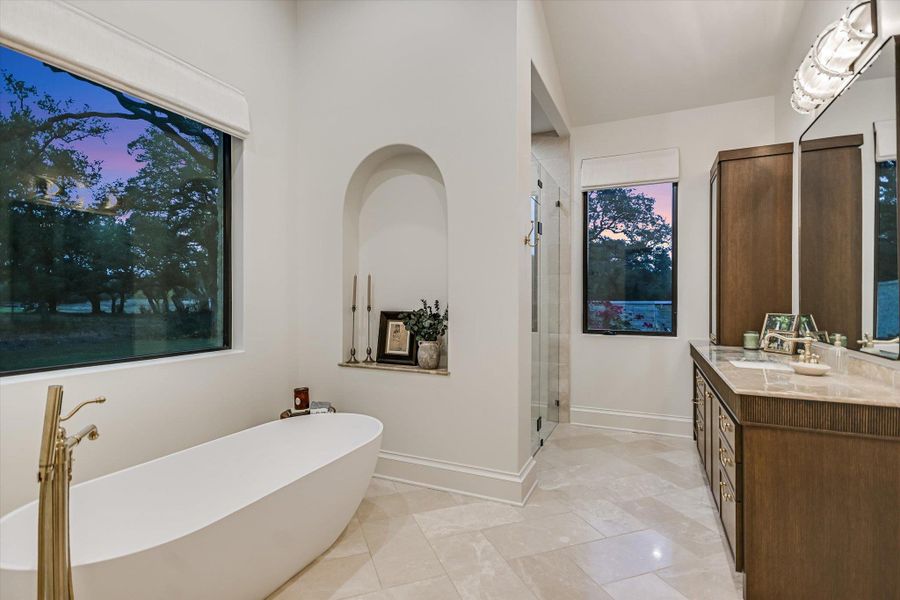 Bathroom featuring a soaking tub, vanity, and a stall shower Bathroom featuring a soaking tub, vanity, and a stall shower