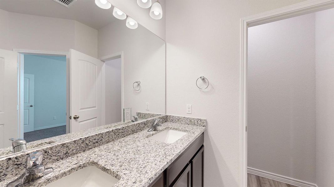 Bathroom featuring double vanity and baseboards