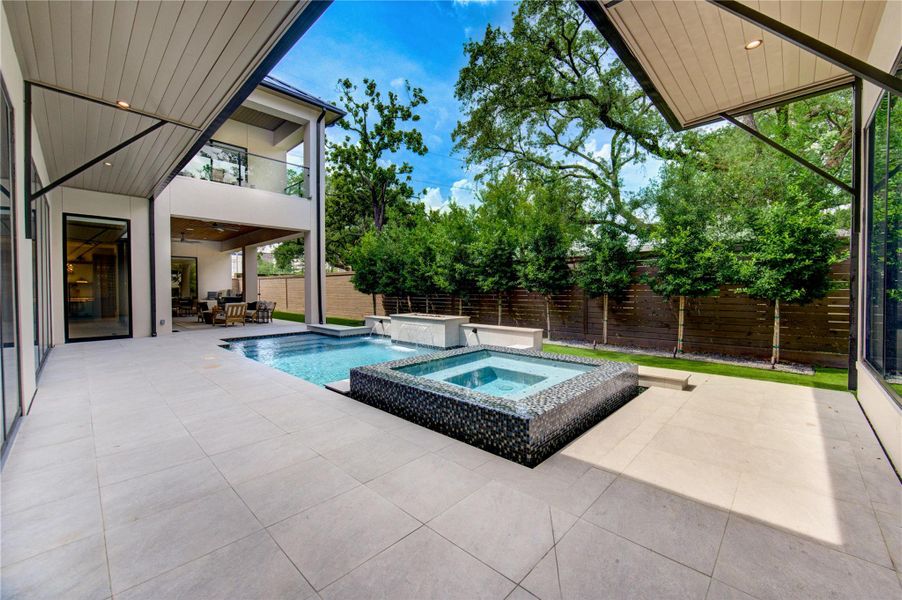 Pool and terrace surrounded by mature landscaping.