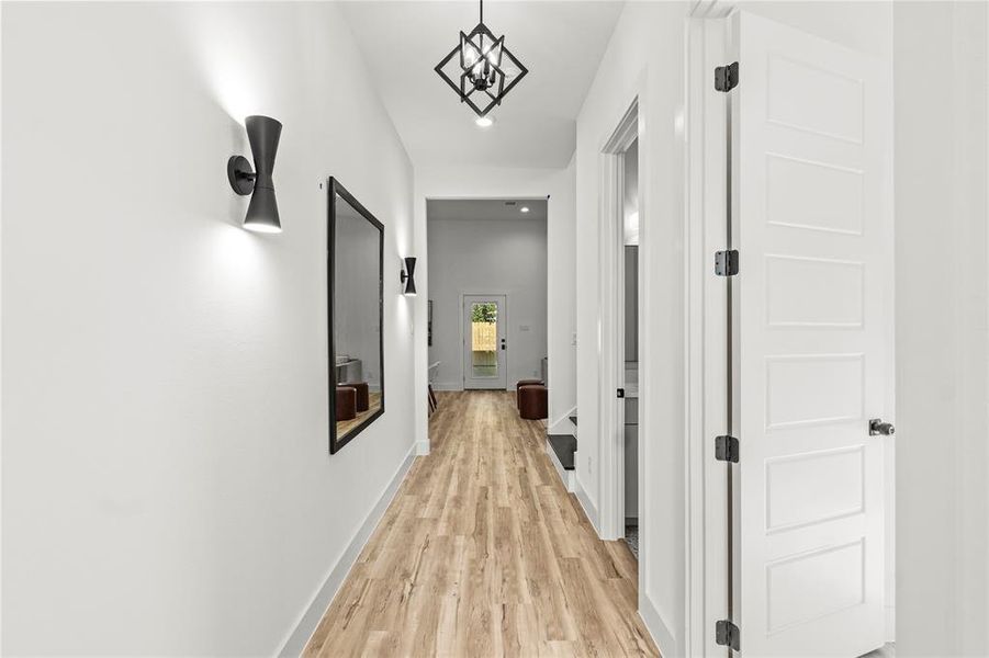 Hallway with light wood-type flooring and recessed lighting