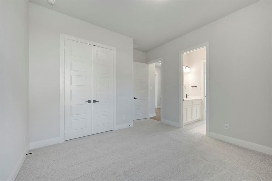 Unfurnished bedroom featuring light colored carpet and a closet