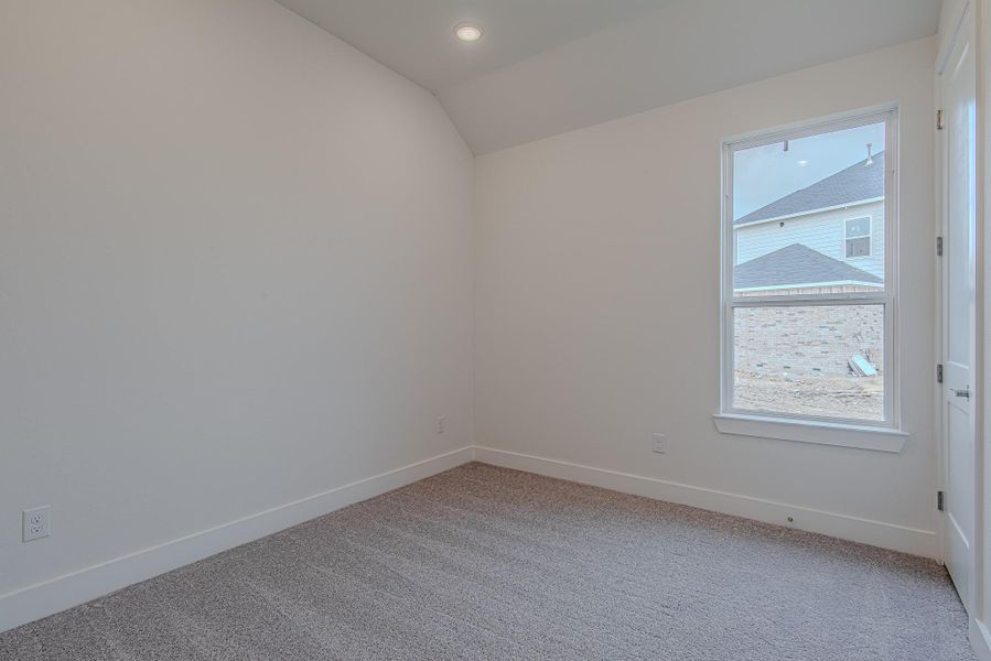 Secondary bedroom with plush carpet, high ceilings, and a large window—ideal for guests, kids, or bonus space. Secondary bedroom with plush carpet, high ceilings, and a large window—ideal for guests, kids, or bonus space.