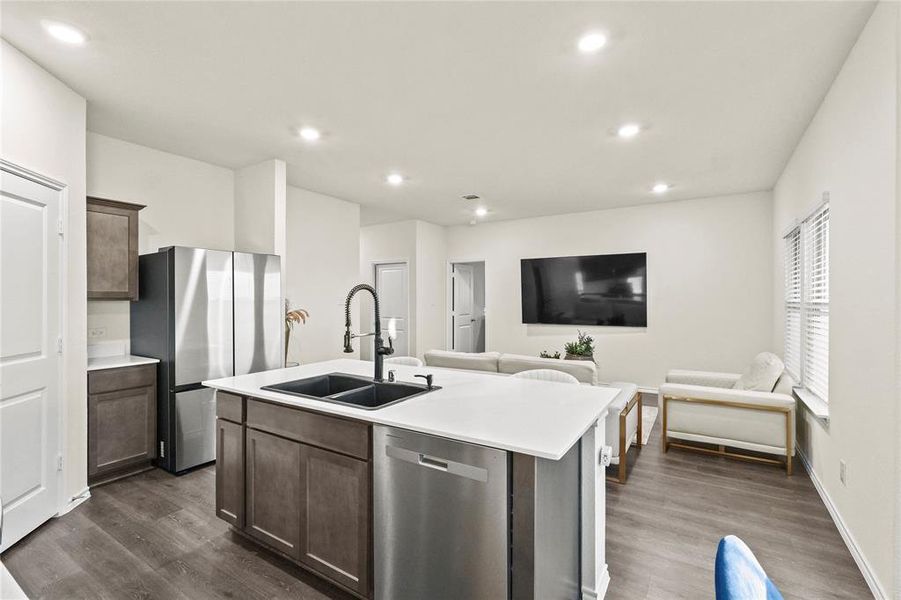 Kitchen with sink, high -end cabinets, a center island with sink, wood-type flooring, and appliances with stainless steel finishes