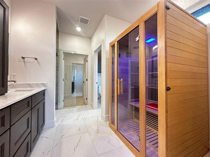 Full bath featuring marble finish floor, vanity, visible vents, and a sauna