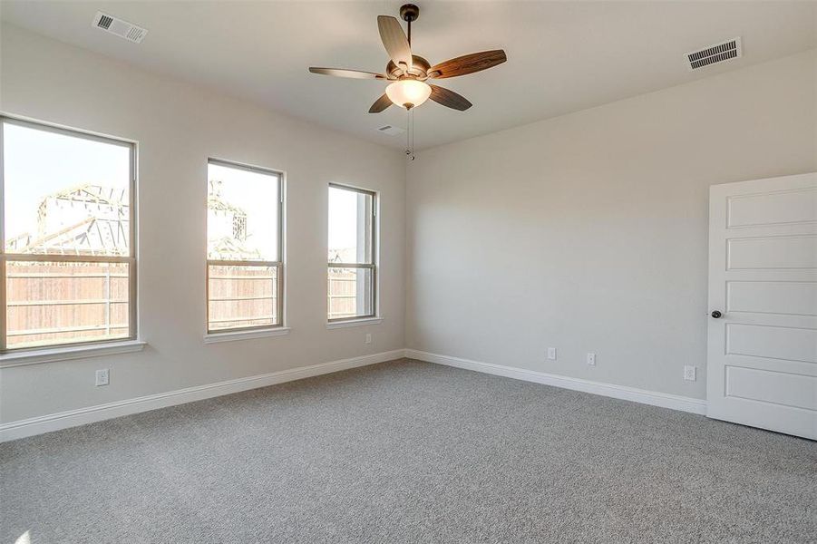 Carpeted empty room with ceiling fan