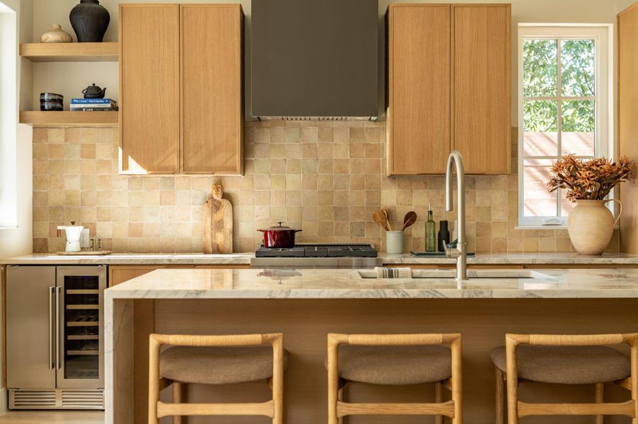 Warm wood cabinetry and stone countertops frame a functional island in this tailored kitchen. Warm wood cabinetry and stone countertops frame a functional island in this tailored kitchen.