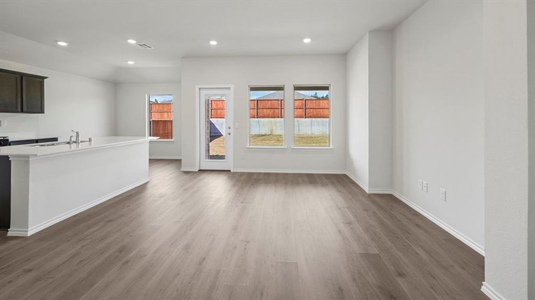 Unfurnished living room featuring dark wood-style flooring and recessed lighting
