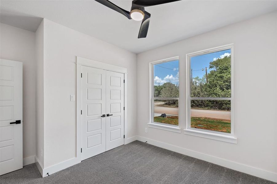 Unfurnished bedroom featuring ceiling fan, a closet, and carpet floors