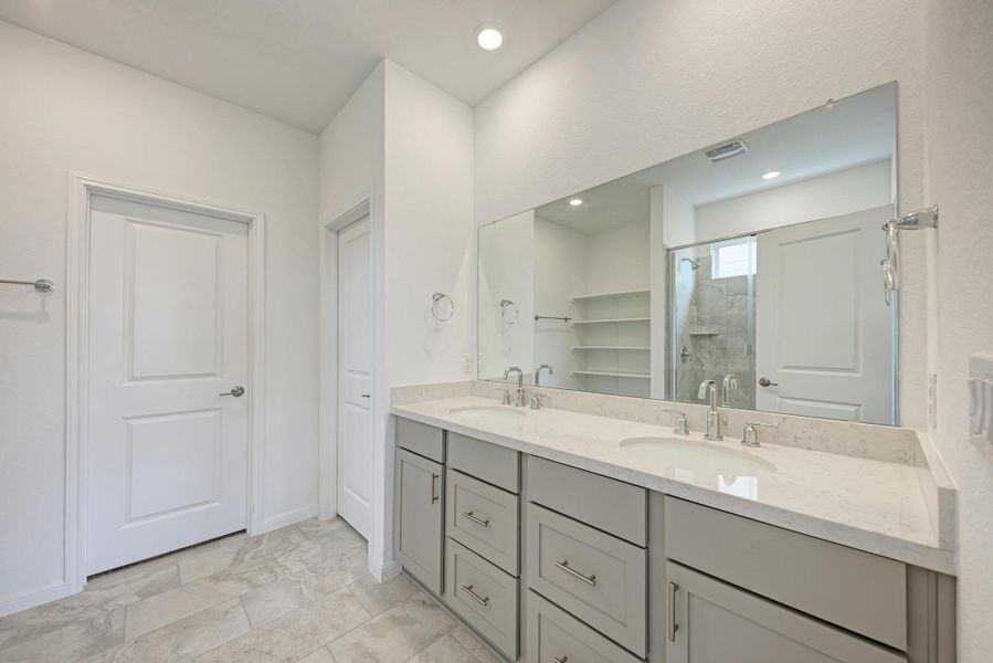 Dual vanities and spacious mirrors create a pristine, functional primary bathroom.