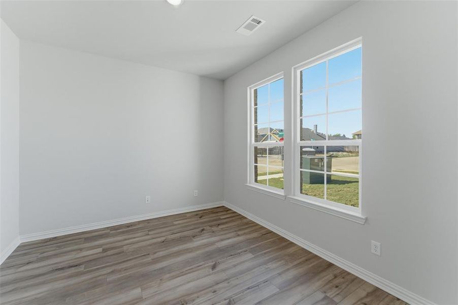 Spare room featuring light wood-type flooring and baseboards