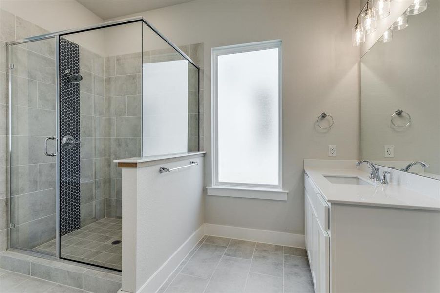 Bathroom with tile patterned flooring, an enclosed shower, and vanity