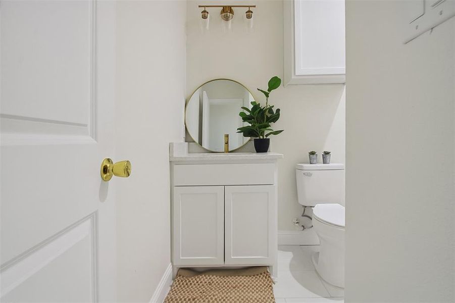 Bathroom featuring vanity, tile patterned floors, and toilet